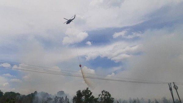 Helikopter water boombing melakukan pemadaman lahan terbakar di sekitar kawasan yang tak jauh dari Bandara Internasional Syamsudin Noor di Banjarbaru. (ANTARA/Firman)