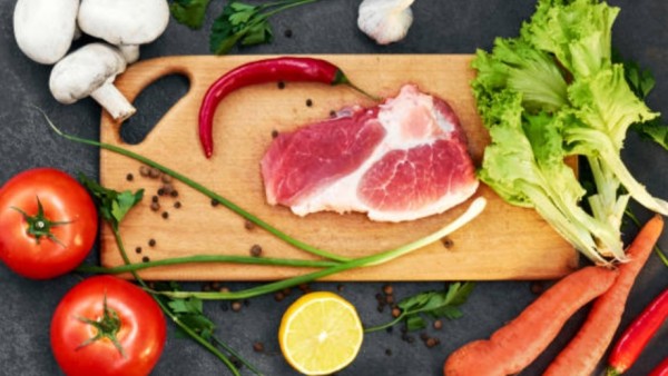 Ilustrasi daging mentah di dekat sayuran segar yang bisa memicu kontaminasi silang.