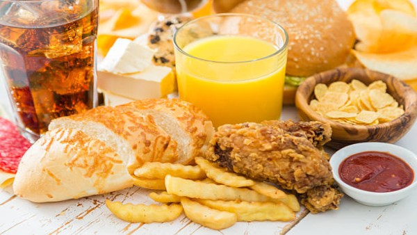 Ilustrasi makanan gorengan, minuman manis, roti putih, dan camilan asin yang disarankan untuk dibatasi setelah usia 50.