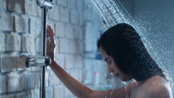 Seorang wanita mandi dalam cahaya temaram, menikmati ketenangan sebelum tidur.