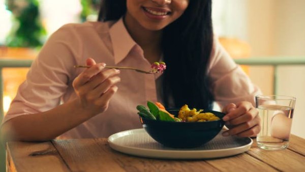 Seorang perempuan menikmati hidangan sehat bernutrisi tinggi untuk kesehatan tulang.