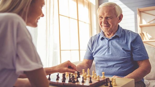 Meja catur dengan bidak di tengah permainan, suasana santai namun penuh konsentrasi.