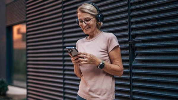 Ilustrasi lansia menikmati musik dengan headphone, menandakan manfaat musik terhadap kesehatan otak.