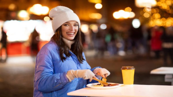 Ilustrasi seseorang menikmati makan malam lebih awal di musim dingin.