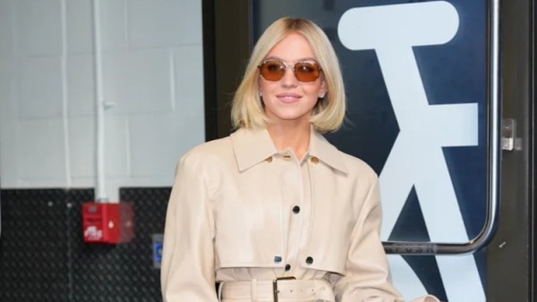 Sydney Sweeney tampil memukau di New York dengan trench coat kulit bergaya mini dress, dipadukan dengan sepatu boots tinggi dan tas Miu Miu.