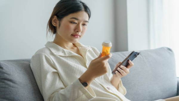 Ilustrasi seseorang menggunakan ponsel untuk mencari informasi kesehatan yang dapat memicu kecemasan berlebihan.