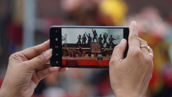 Ilustrasi seseorang menonton video pendek di ponsel, menggambarkan dampak konsumsi berlebihan terhadap otak dan fokus.