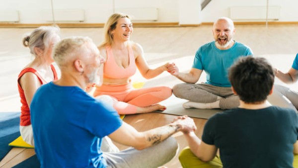 Aktivitas yoga tertawa yang dilakukan bersama-sama, menggambarkan ekspresi bahagia dan manfaat positif tertawa bagi kesehatan tubuh dan pikiran.