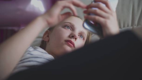 Ilustrasi anak remaja sedang menatap layar smartphone, mencerminkan dilema orang tua di era digital.