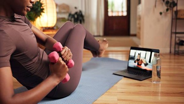 Ilustrasi seseorang berolahraga menggunakan aplikasi fitness di rumah dengan panduan digital.