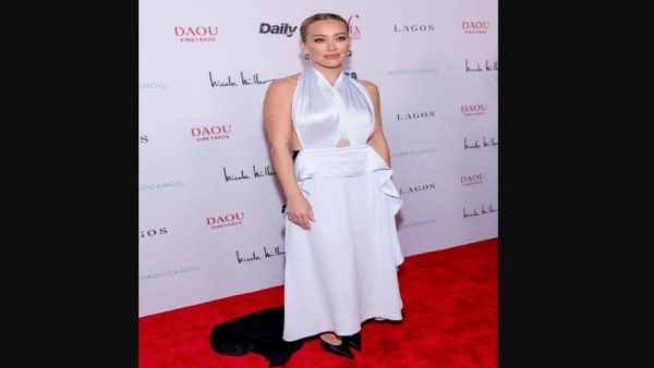 Hilary Duff tampil mengenakan gaun backless dua warna rancangan Victoria Beckham di ajang Fashion Los Angeles Awards dengan detail elegan dan dramatis di bagian belakang.