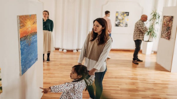 Seorang ibu dan anak sedang menikmati karya seni di galeri, menunjukkan bagaimana aktivitas seni dapat memberikan ketenangan sekaligus manfaat kesehatan.