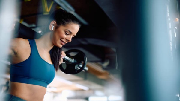 Ilustrasi seseorang sedang melakukan latihan angkat beban di gym dengan energi optimal dan pola makan sehat.