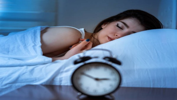 Ilustrasi seseorang tidur nyaman di kamar tidur pada malam hari setelah melakukan penyesuaian sederhana untuk meningkatkan kualitas istirahat.
