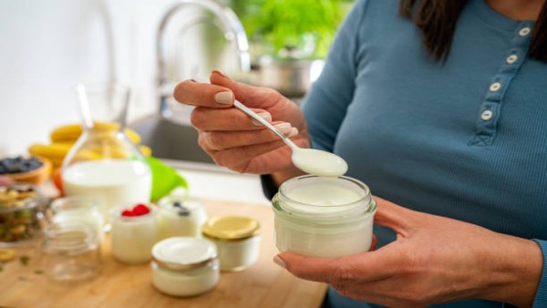 Segelas yogurt probiotik dengan buah segar di atas meja kayu, menggambarkan gaya hidup sehat dan keseimbangan pencernaan.