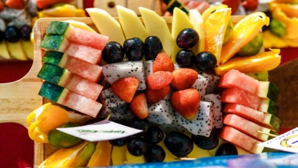 Ilustrasi aneka buah segar seperti semangka, stroberi, blueberry, persik, dan mangga yang kaya vitamin serta cocok dikonsumsi saat cuaca panas.