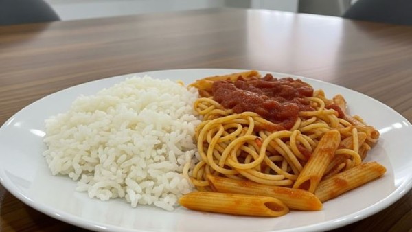 Ilustrasi sepiring nasi dan pasta yang sering dibandingkan sebagai sumber karbohidrat untuk menjaga kadar gula darah.